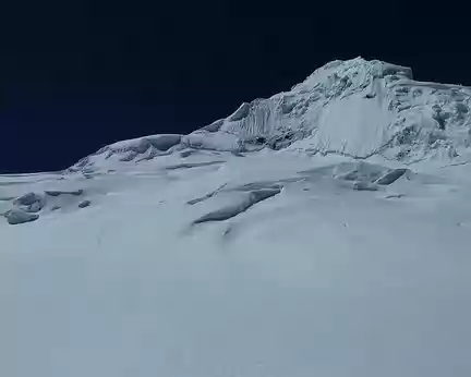 PXL025 Avec un coup de zoom on peut suivre la trace qui slalome entre les crevasses et rejoint l'arête à droite de l'épaule cornichée (pas simple de nuit...)