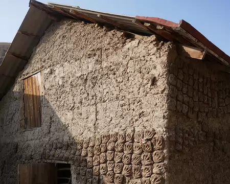 Bouses de vache mises à sécher sur le mur d'une maison.