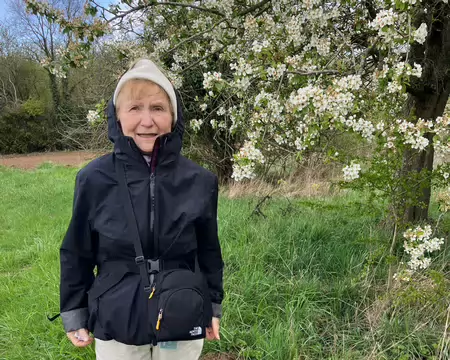 Mounia, frigorifiée devant un pommier en fleur.