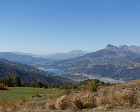 FM9A4275 Le Lac de Serre-Ponçon traversé par le pont de Savines. Au loin avec un peu de neige, le Pic de Bure (2709m) situé dans le Dévoluy ; Plus à droite les Aiguilles...